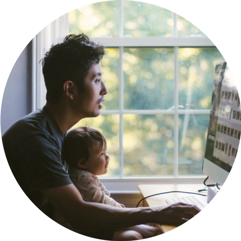 A parent with smiling baby on lap browses the internet